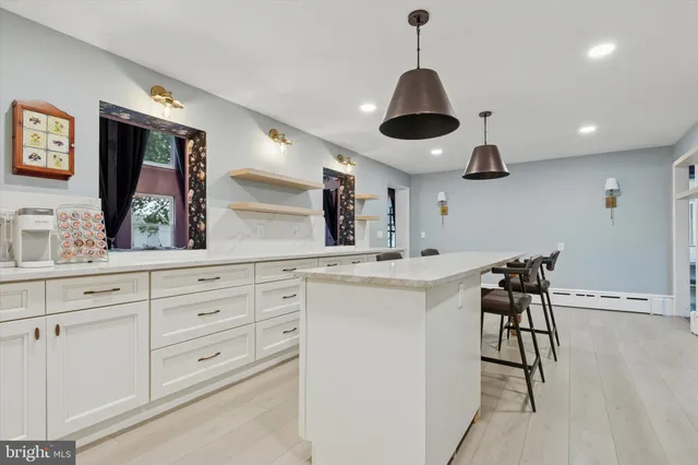 a kitchen with stainless steel appliances a stove a chandelier and a sink