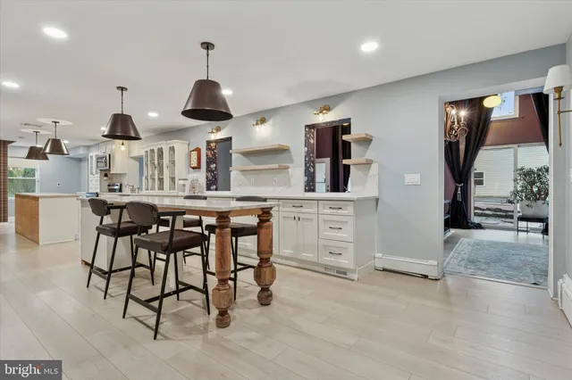 a kitchen with stainless steel appliances kitchen island granite countertop a table and chairs in it