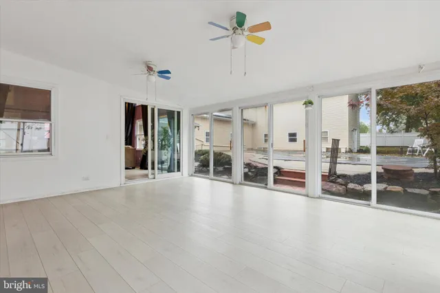 a view of a livingroom with furniture a ceiling fan and window