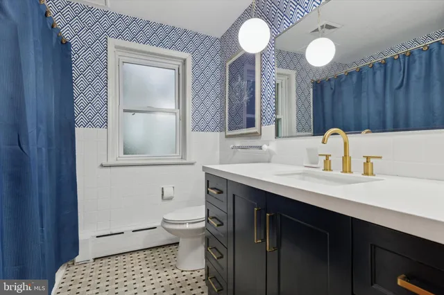 a bathroom with a sink a toilet and a mirror