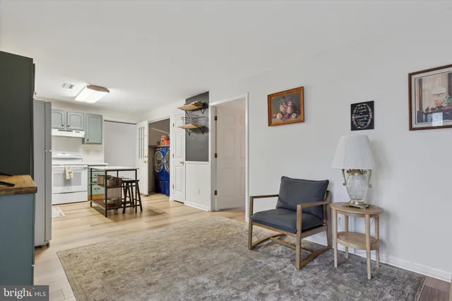 a living room with furniture a dining table and a refrigerator
