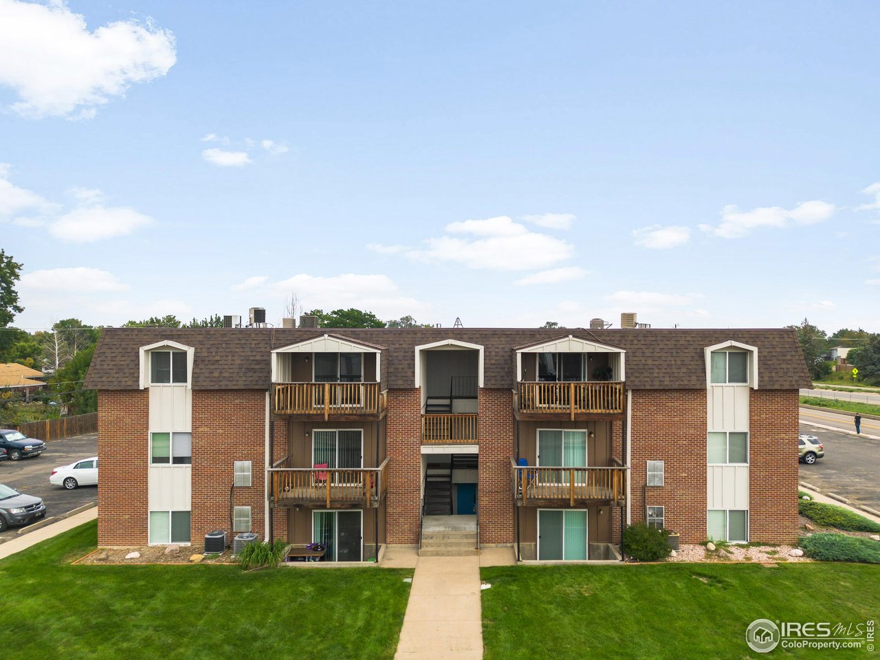 1817 26th Street Greeley, CO 80631 - Photo 27 of 29 a front view of a residential apartment building with a yard
