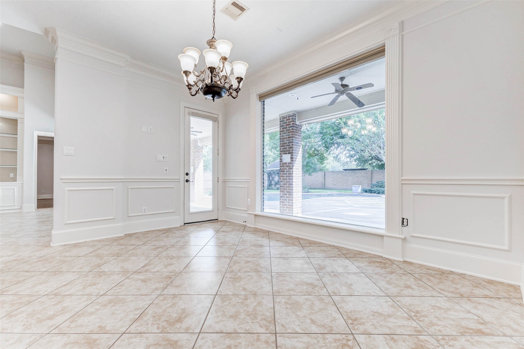 3509 Mirror Court Spring, TX 77388 - Photo 15 of 45 The bright breakfast nook offers a charming place to start your day, featuring a large picture window with peaceful views of the backyard and pool. Classic wainscoting, tile flooring, and a timeless chandelier add elegance to this inviting dining space.
