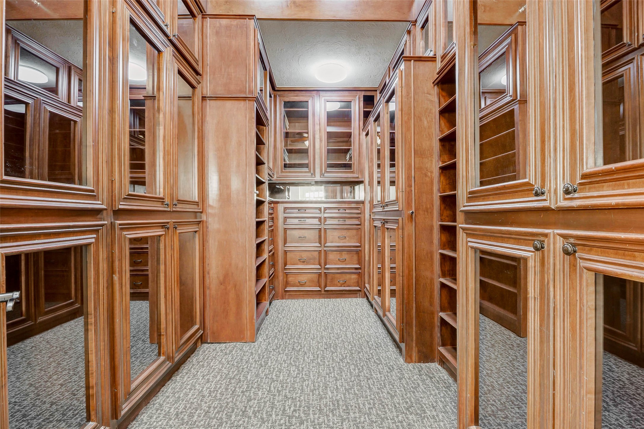 3509 Mirror Court Spring, TX 77388 - Photo 21 of 45 The custom-designed primary closet offers an abundance of built-in cabinetry, glass-front storage, and extensive shelving. Stunning panels, dedicated drawer space, and thoughtful organization features create a boutique-style dressing experience.