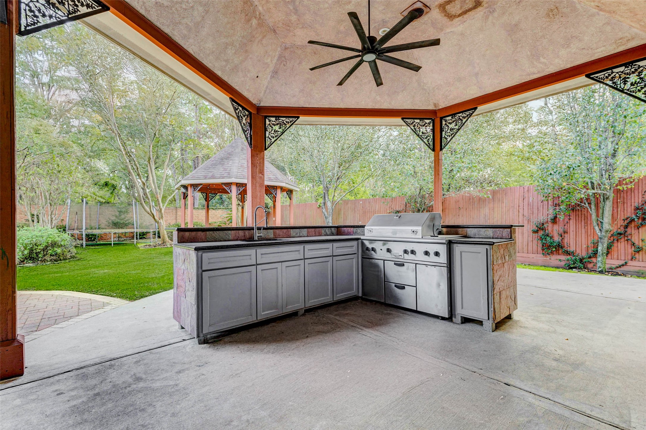 3509 Mirror Court Spring, TX 77388 - Photo 33 of 45 The outdoor kitchen is fully equipped with ample counter space, a built-in grill, and a prep sink, making it effortless to cook and entertain outdoors. Surrounded by lush landscaping and views of the gazebo, it’s the perfect spot for weekend gatherings.