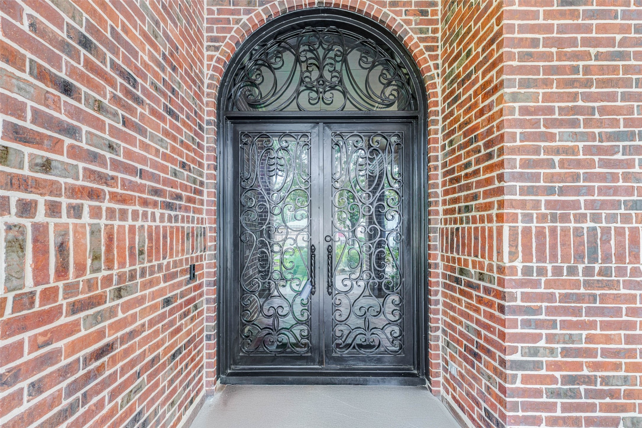 3509 Mirror Court Spring, TX 77388 - Photo 4 of 45 Follow the landscaped pathway to your grand arched entry that welcomes guests with custom wrought-iron double doors set against an elegant brick surround, creating a striking first impression as you approach the home.