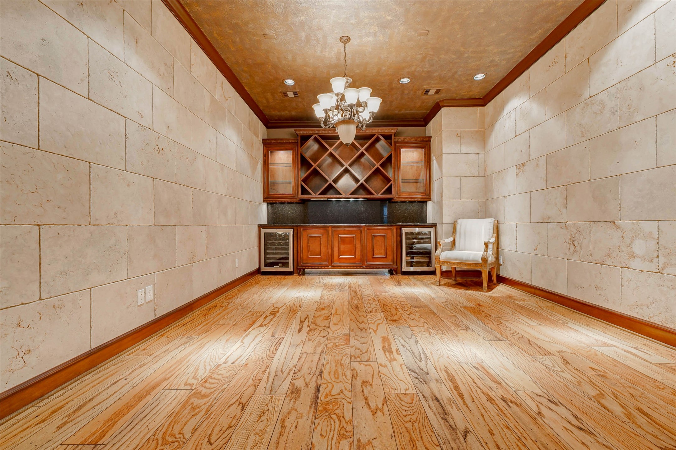 3509 Mirror Court Spring, TX 77388 - Photo 7 of 45 The impressive wine room/dining room showcases custom cabinetry, dual wine refrigerators, and an expansive storage display. Wood flooring, stone-accented walls, and elegant lighting create a refined setting ideal for tastings or intimate gatherings.
