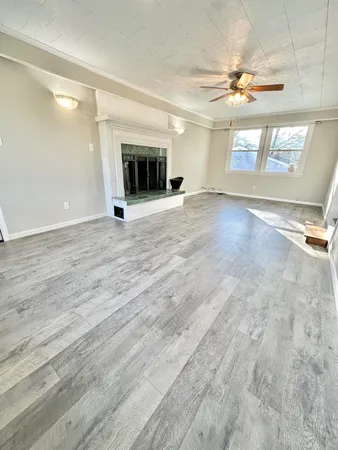 an empty room with windows and fireplace