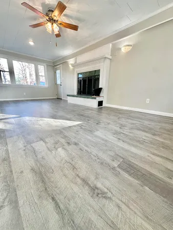 an empty room with fan and windows