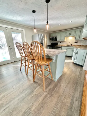 a kitchen with stainless steel appliances granite countertop a kitchen island a stove a table and chairs