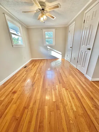 a view of empty room with wooden floor