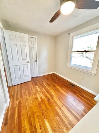 a view of a room with wooden floor and white walls