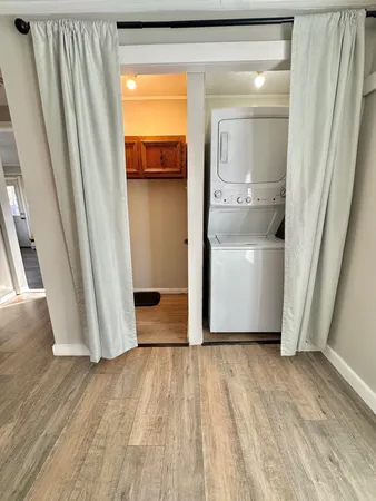 a view of a hallway with wooden floor and a cabinet