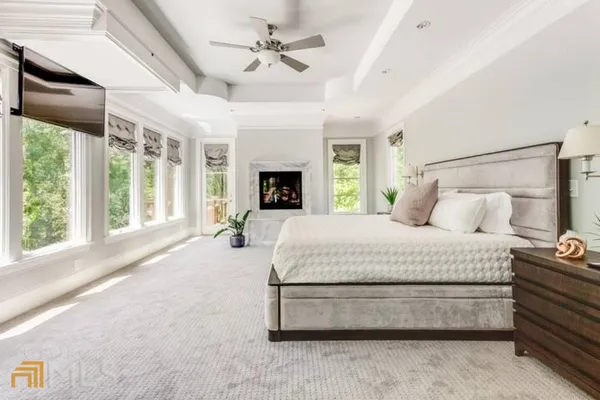 a spacious bedroom with a large bed and a chandelier