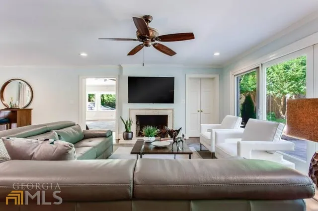 a living room with furniture a fireplace and a large window