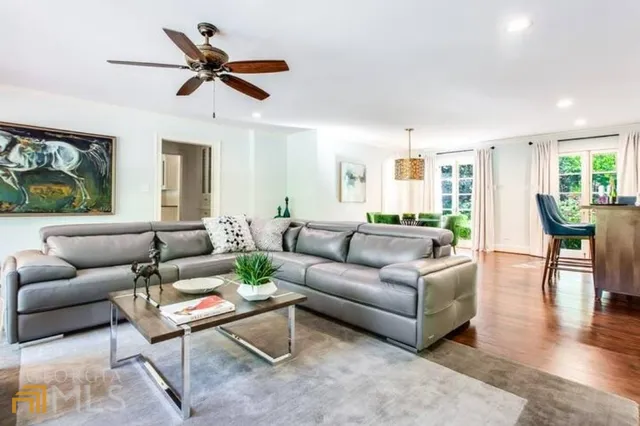 a living room with furniture and a view of kitchen