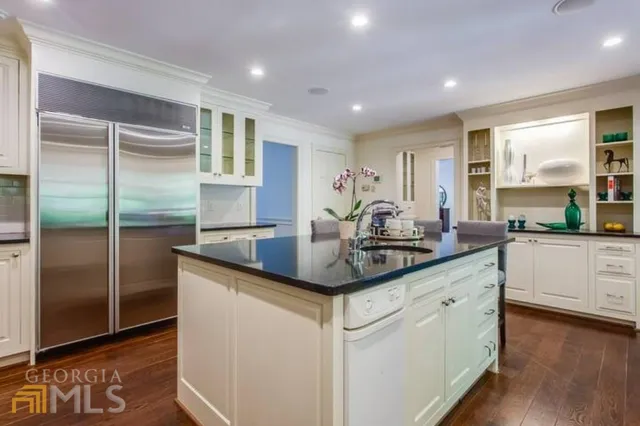 a kitchen with stainless steel appliances granite countertop a sink and a refrigerator