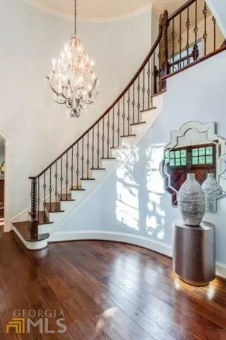 a view of a hallway with wooden floor and staircase