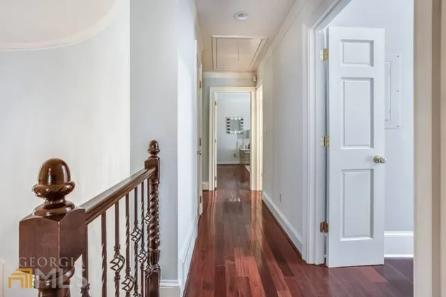 a view of a hallway with wooden floor and stairs
