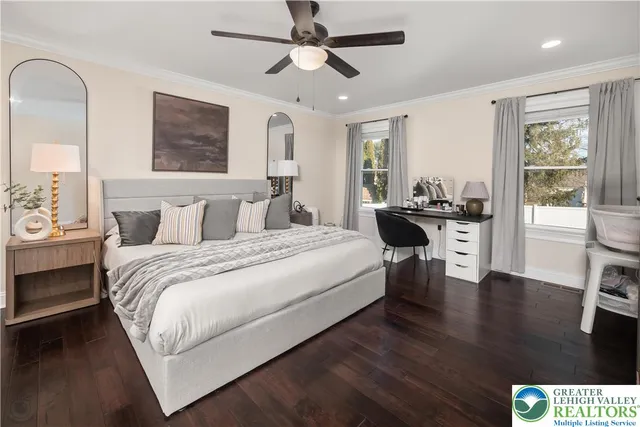 a bedroom with a bed furniture and a flat tv screen