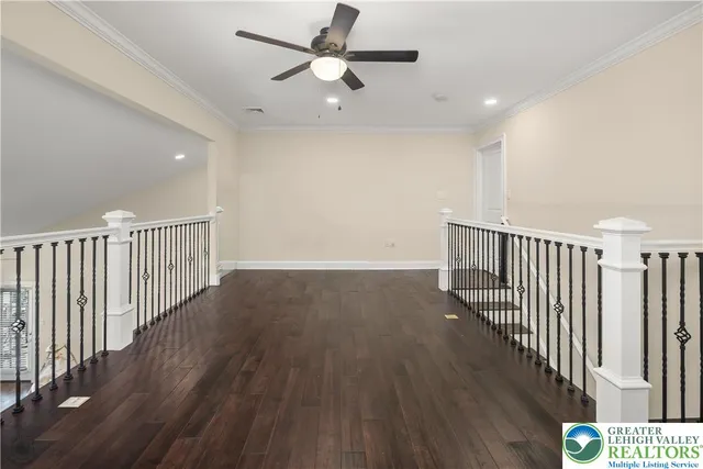a view of a room with wooden floor fan and windows