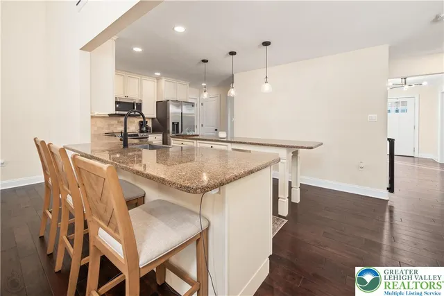 a kitchen with white cabinets appliances and wooden floor