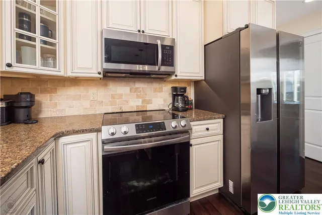 a kitchen with stainless steel appliances granite countertop a sink a stove and a microwave