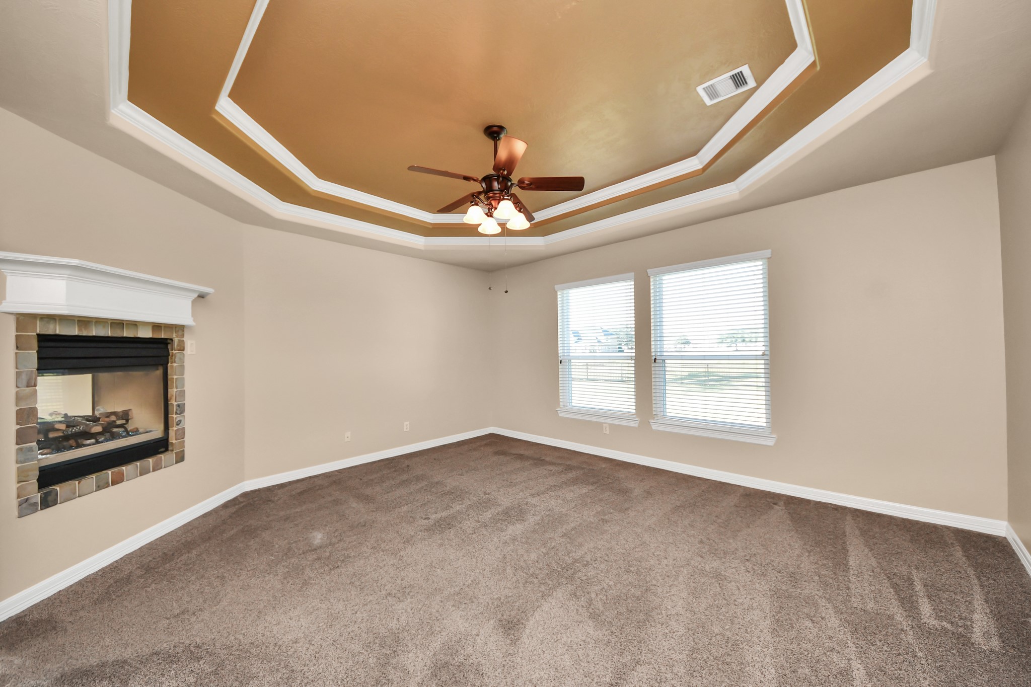 3511 River Bend Drive Rosenberg, TX 77471 - Photo 20 of 50 Spacious master bedroom featuring a cozy fireplace and elegant coffered ceilings