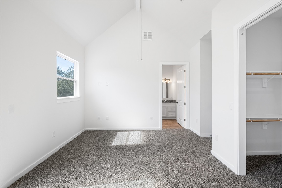 255 Lourdes Court, Unit A Dripping Springs, TX 78620 - Photo 13 of 27 a view of an empty room with wooden floor and a bathroom