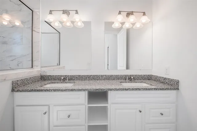 a bathroom with a granite countertop sink a toilet and a mirror