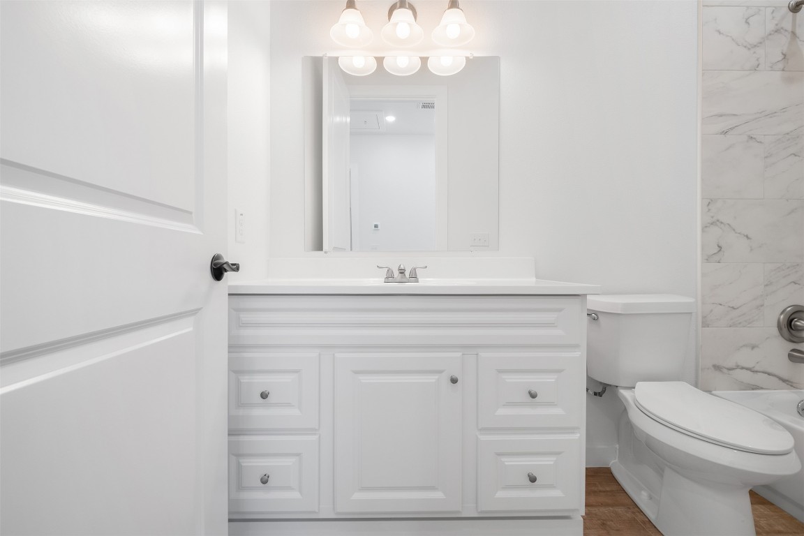 255 Lourdes Court, Unit A Dripping Springs, TX 78620 - Photo 26 of 27 a bathroom with a sink a toilet and a mirror