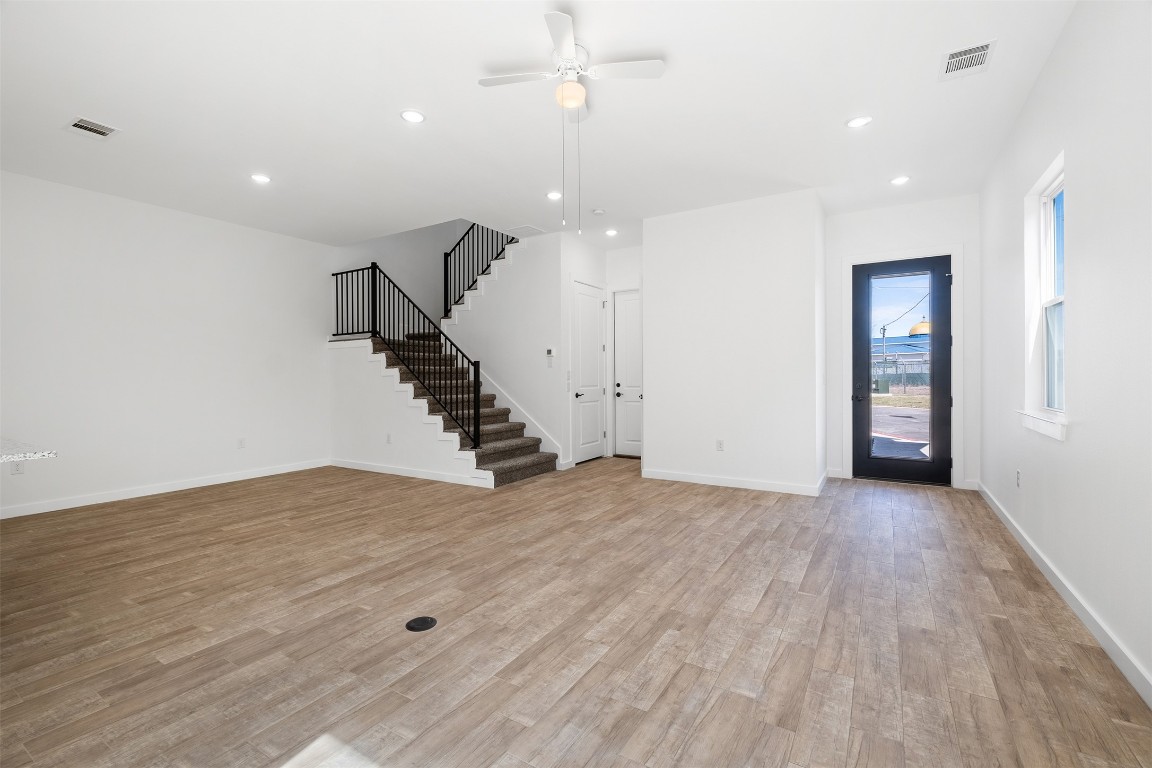 255 Lourdes Court, Unit A Dripping Springs, TX 78620 - Photo 6 of 27 a view of an empty room with wooden floor and stairs