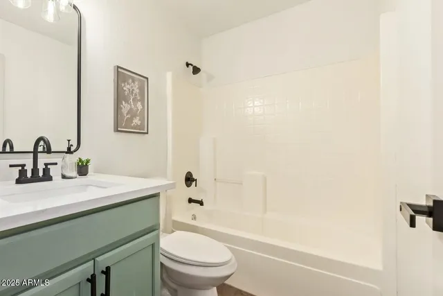 a bathroom with a sink toilet vanity and shower
