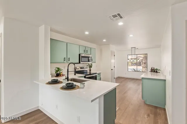 a kitchen with sink refrigerator and cabinets