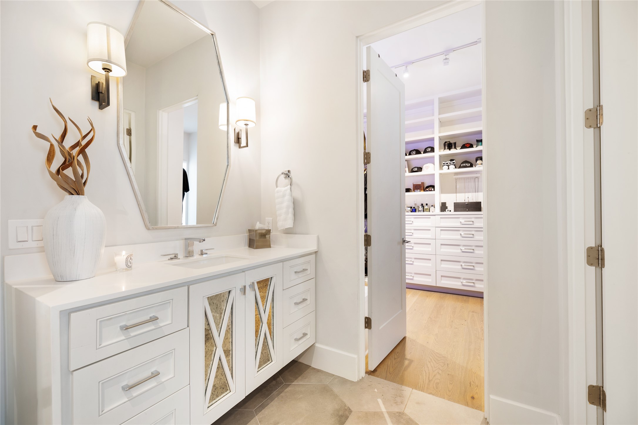 103 Roy Street Houston, TX 77007 - Photo 24 of 37 Elegant secondary vanity connects directly to a custom walk-in closet, creating a seamless daily routine with tailored storage, built-in drawers, and boutique-style display shelving for a polished, organized lifestyle experience.