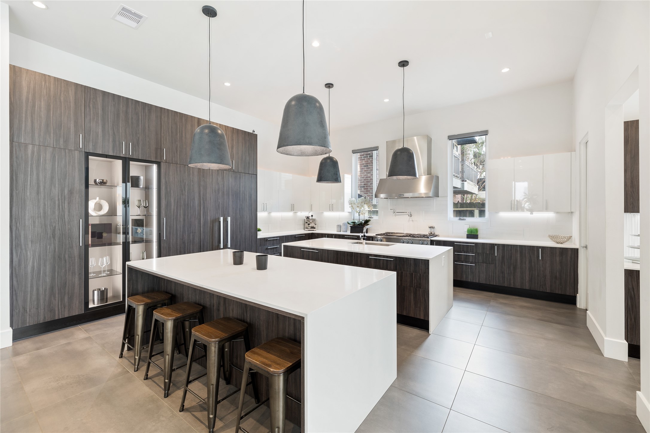 103 Roy Street Houston, TX 77007 - Photo 10 of 37 Modern chef’s kitchen featuring waterfall-edge island surfaces, custom cabinetry, professional-grade appliances, and statement pendant lighting. Designed for both functionality and visual impact, the space anchors the home’s open-concept living experience.