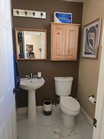 a bathroom with a toilet sink and mirror