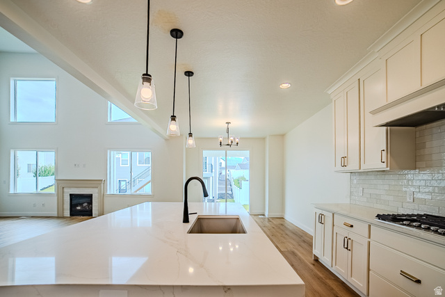 223 South Cottonwood Road, Unit 7501 Vineyard, UT 84059 - Photo 40 of 45 Spacious kitchen island with an undermount sink and matte black faucet, featuring white cabinetry, a tiled backsplash, and recessed lighting