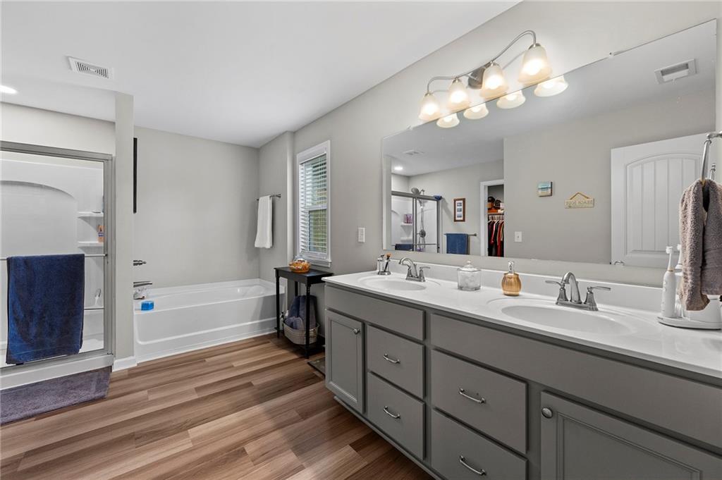 230 Augusta Walk Canton, GA 30114 - Photo 29 of 56 a bathroom with a double vanity sink a mirror and a bathtub