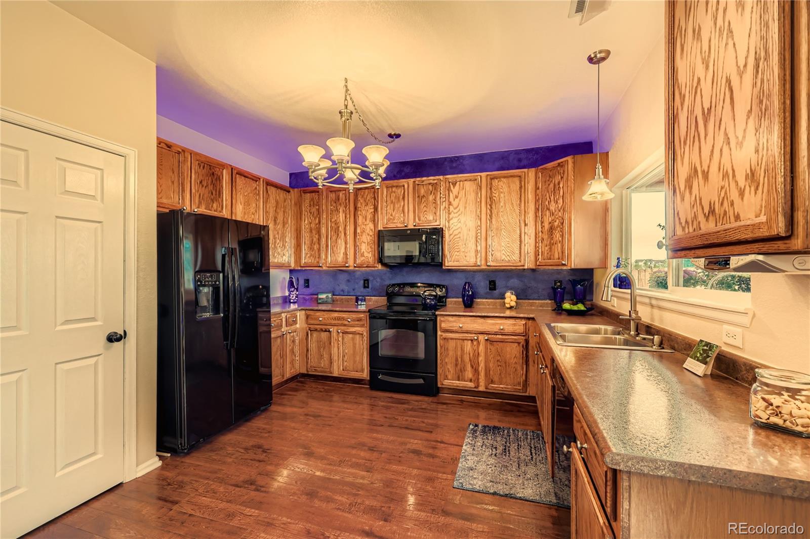 1005 Parsons Avenue Castle Rock, CO 80104 - Photo 11 of 38 a kitchen with a refrigerator sink and wooden cabinets