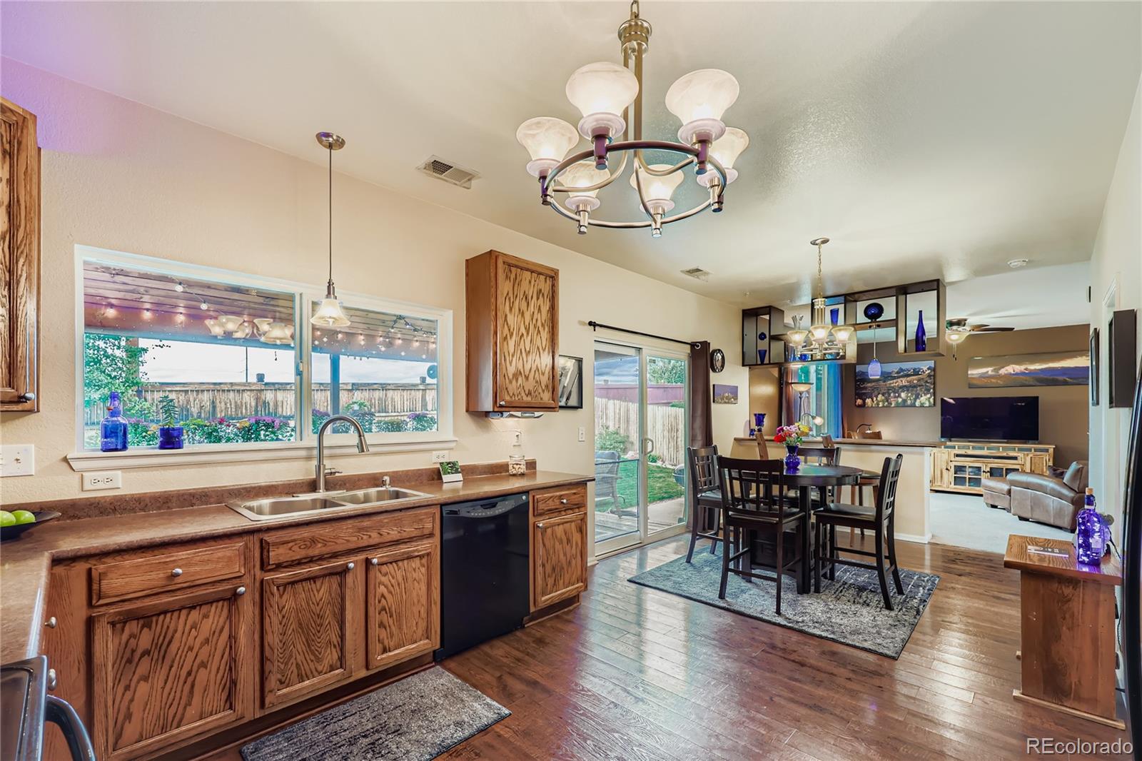 1005 Parsons Avenue Castle Rock, CO 80104 - Photo 12 of 38 a open kitchen with stainless steel appliances granite countertop a stove top oven a dining table and chairs with wooden floor
