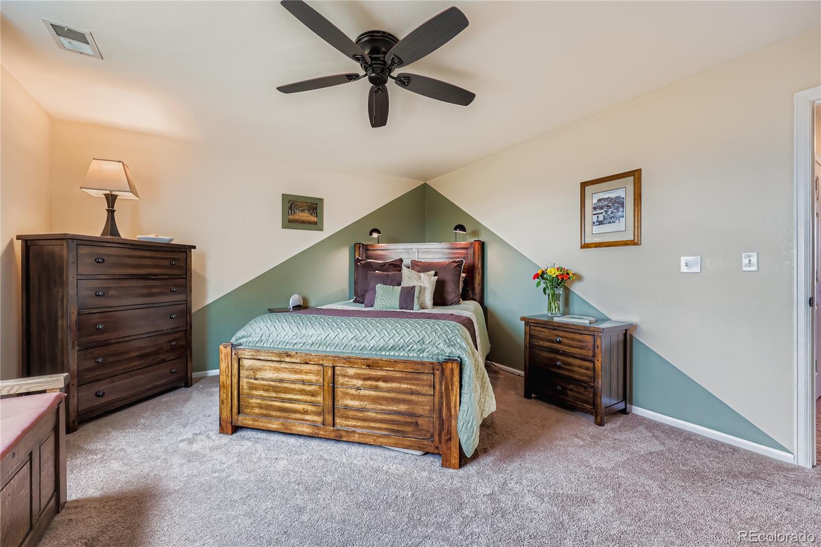 1005 Parsons Avenue Castle Rock, CO 80104 - Photo 16 of 38 a bedroom with a bed and a chandelier