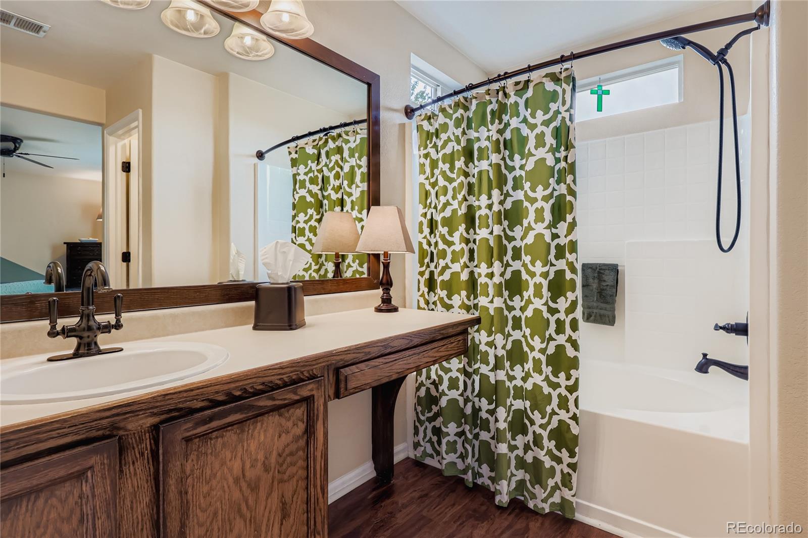 1005 Parsons Avenue Castle Rock, CO 80104 - Photo 18 of 38 a bathroom with a granite countertop sink a mirror a vanity and a shower