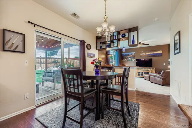 a view of a dining room with furniture a chandelier and wooden floor