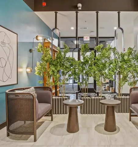 a dining room with couches chairs and potted plants