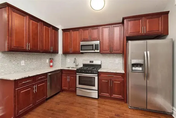 a kitchen with granite countertop wooden cabinets and stainless steel appliances
