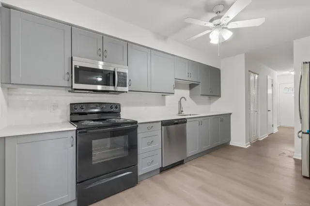 a kitchen with granite countertop a sink stove and refrigerator