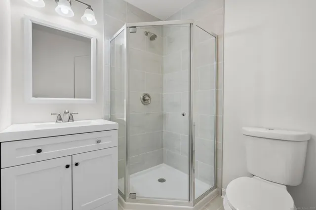 a bathroom with a shower sink vanity and mirror