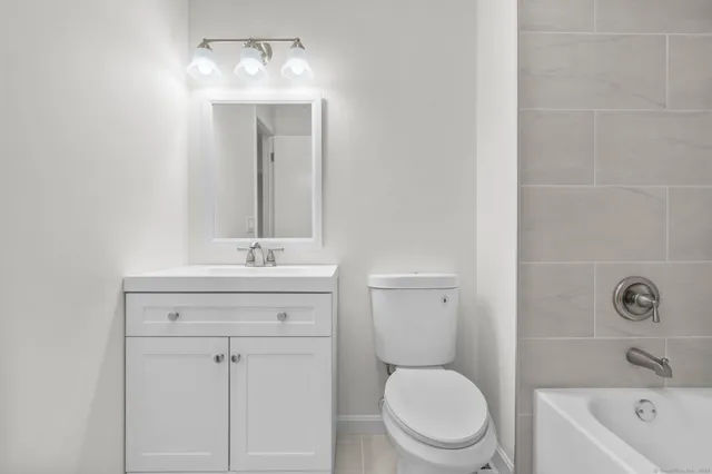 a bathroom with a sink a toilet a mirror and shower