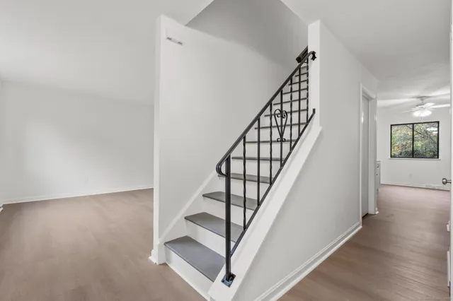 a view of staircase with wooden floor and white walls